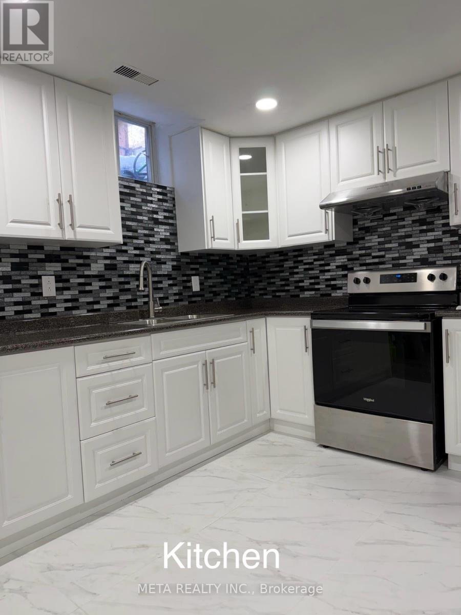 A kitchen with white cabinets and a black oven.