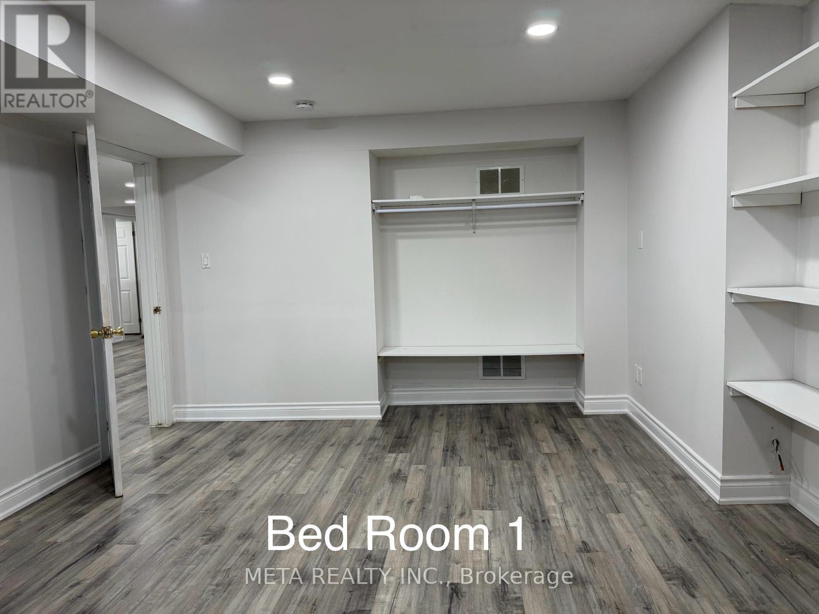 A bedroom with a bed and a shelf in the corner.