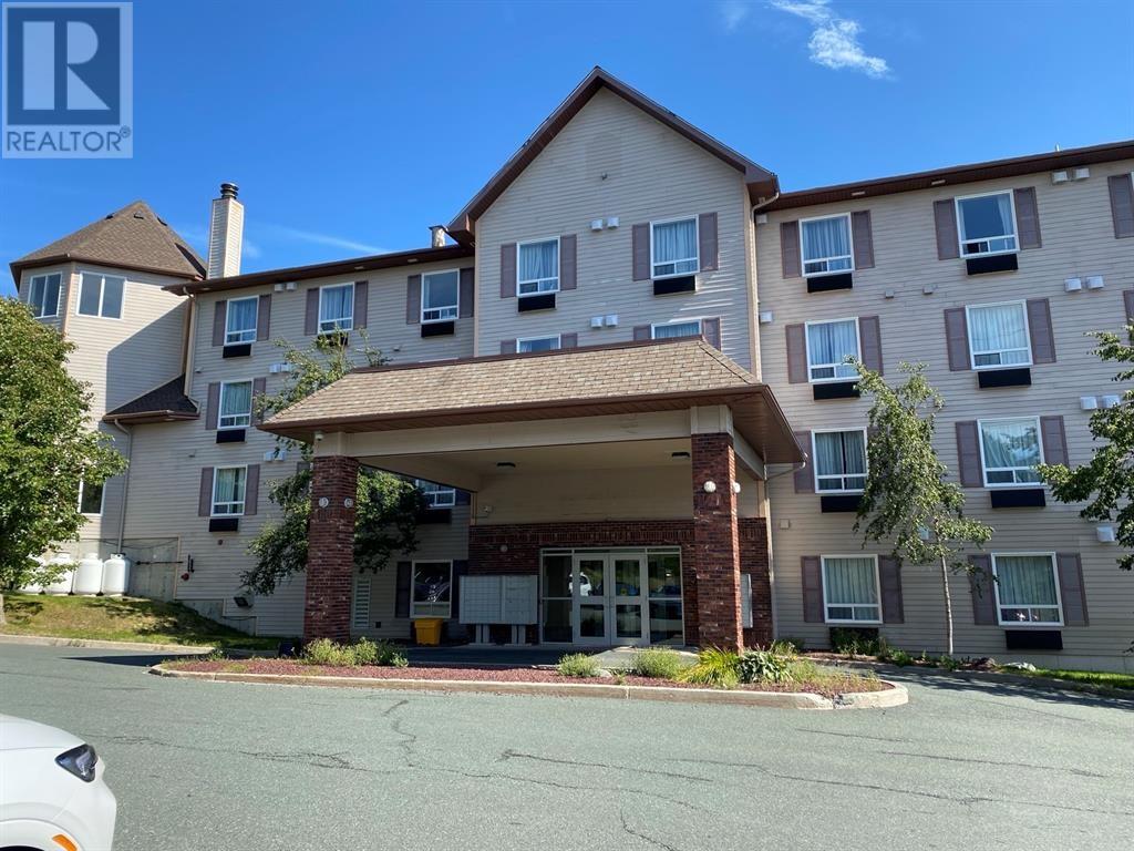 A large apartment complex with a car parked in front.