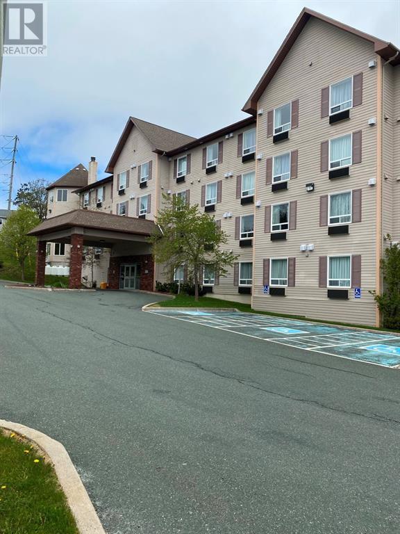 A large apartment complex with a parking lot in front.