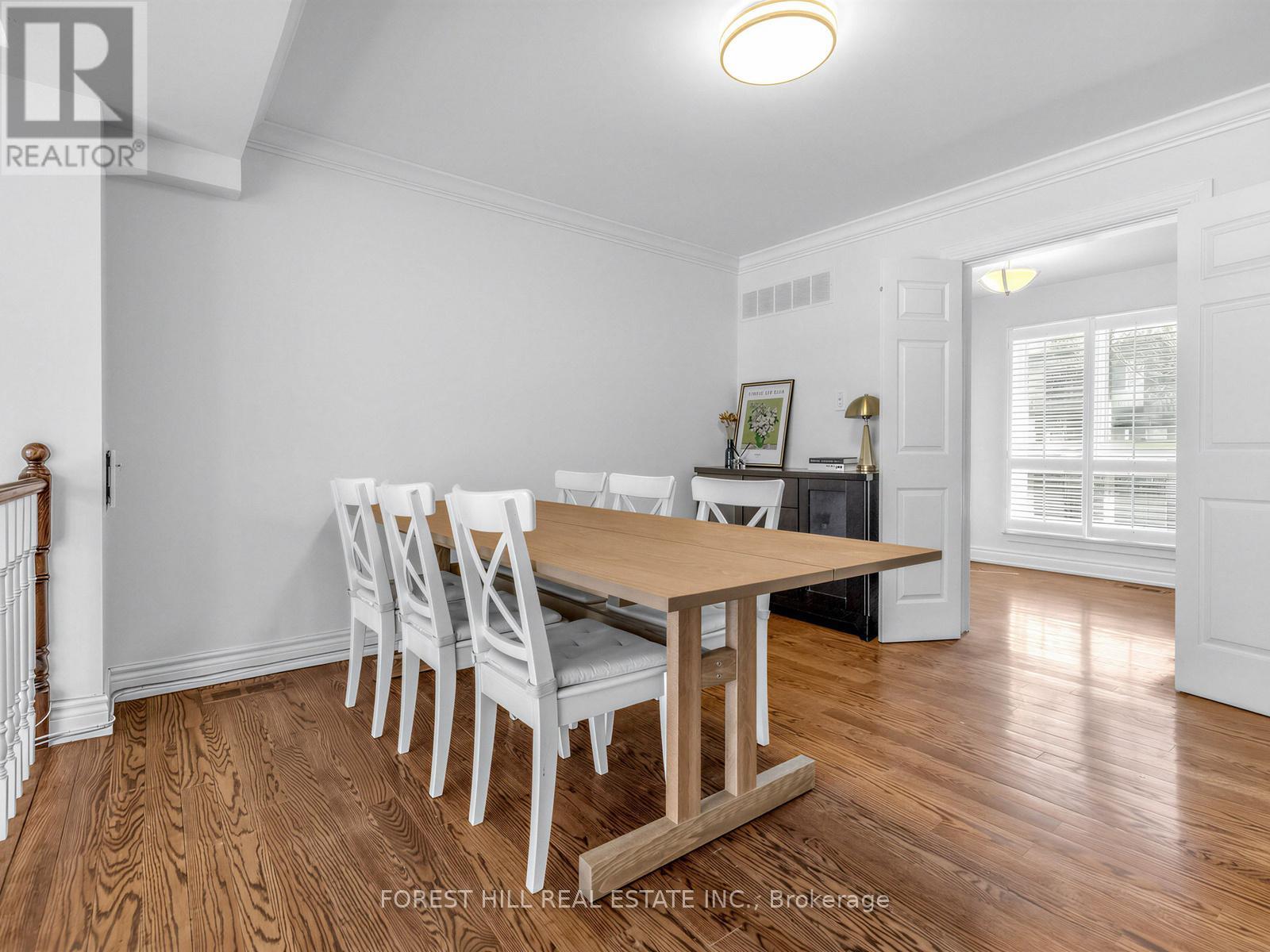 A dining room with a wooden table and chairs.