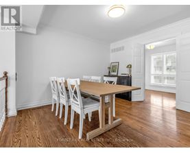 A dining room with a wooden table and chairs.