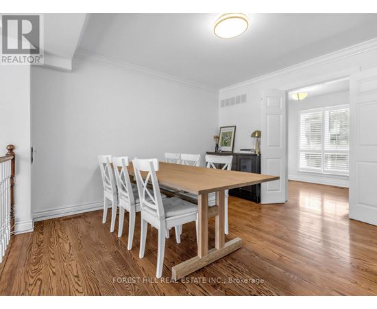 A dining room with a wooden table and chairs.