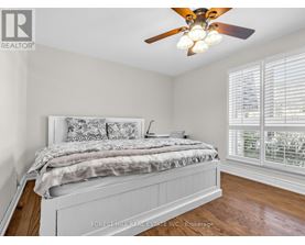 A bedroom with a large bed and a ceiling fan.