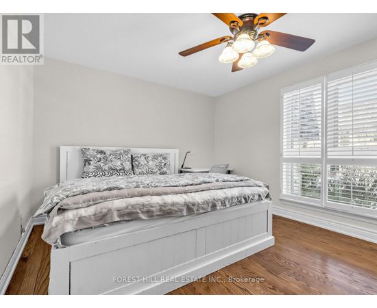 A bedroom with a large bed and a ceiling fan.