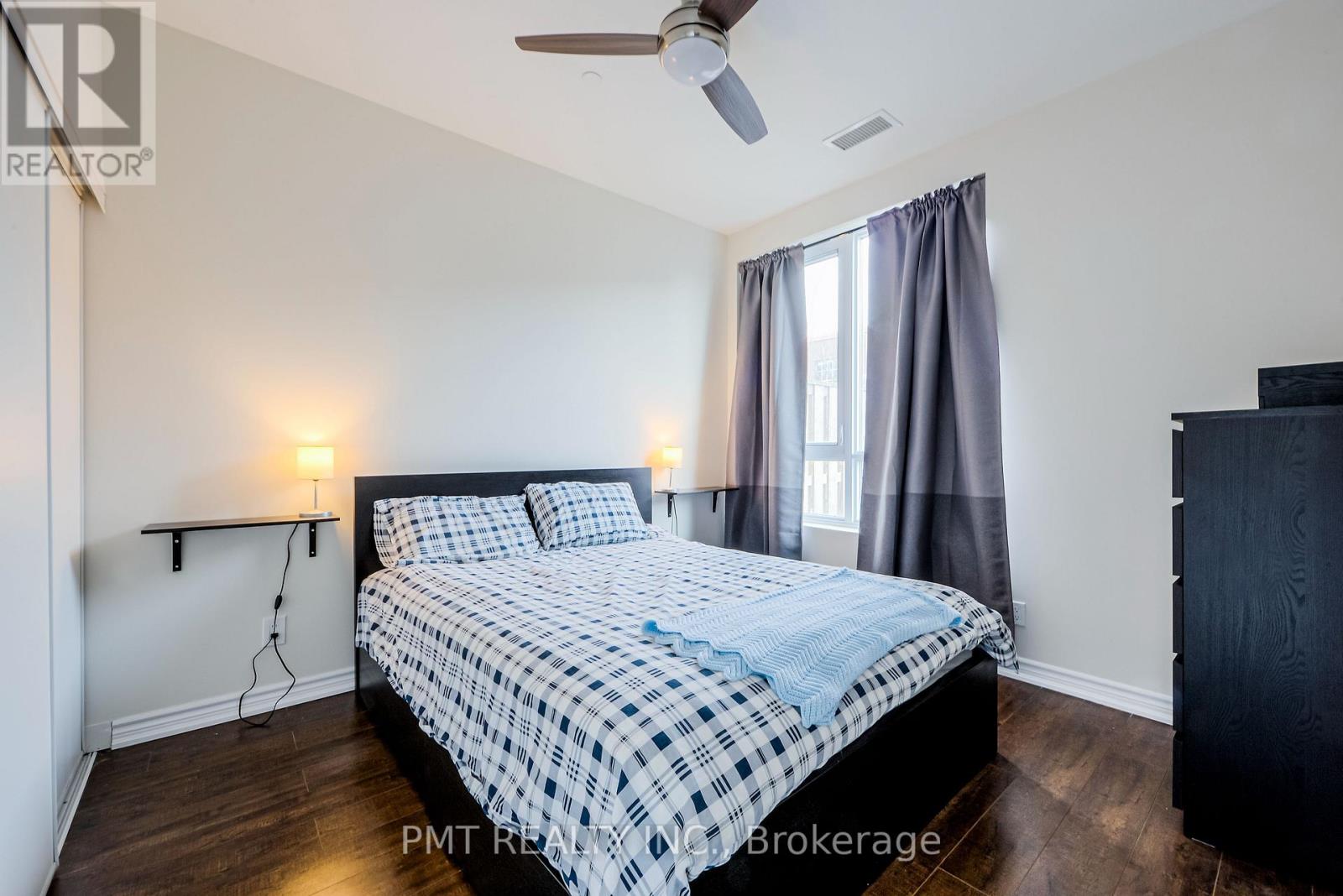 A bedroom with a bed, nightstands, and a ceiling fan.