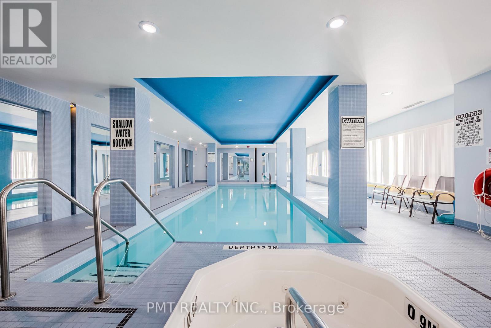A large indoor swimming pool with a slide.