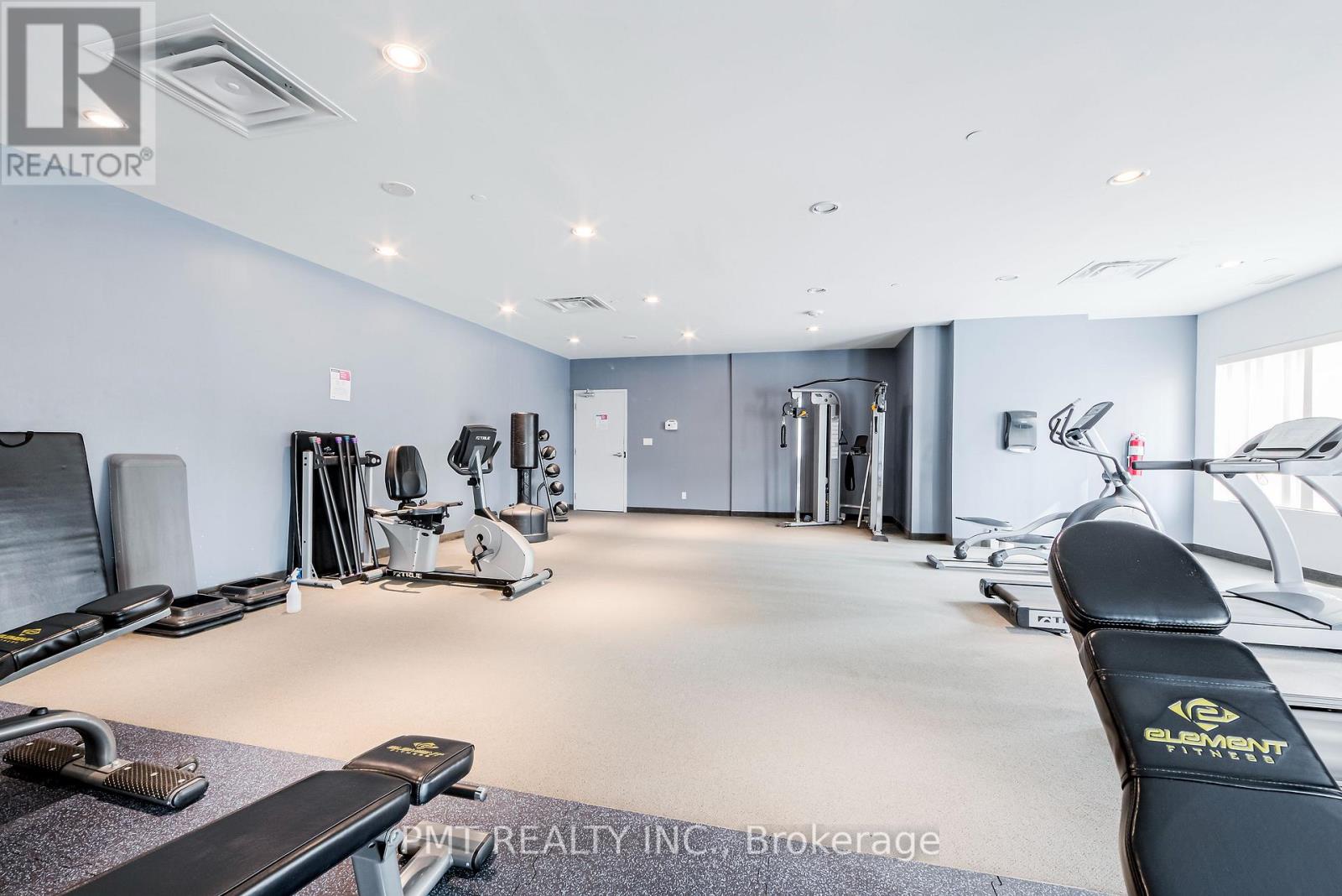 A well-lit gym with various exercise equipment.