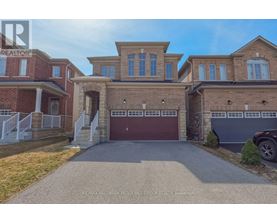 A large, two-story house with a garage is for sale.