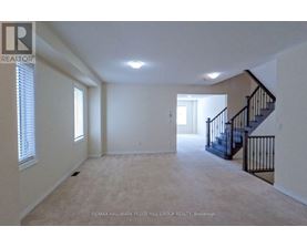 A spacious room with a staircase and a window.