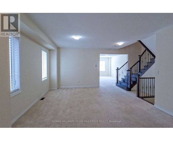 A spacious room with a staircase and a window.