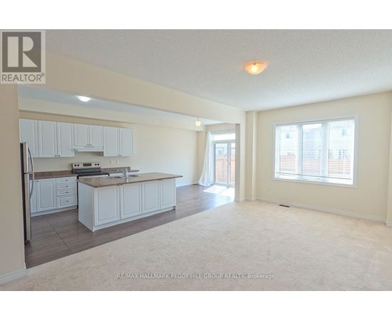 A spacious kitchen and living room with white cabinets and a large island.