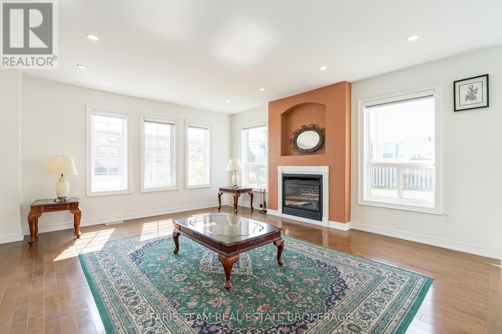 A living room with a fireplace and a rug on the floor.