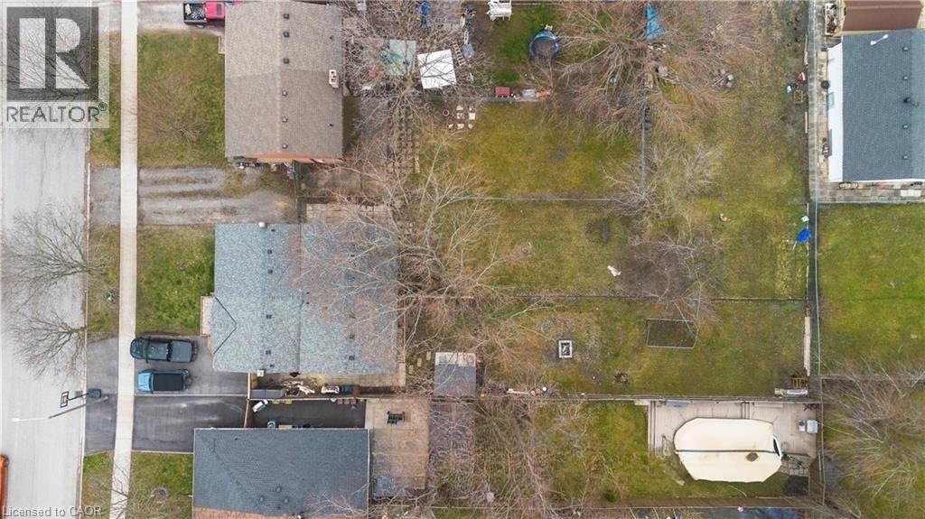 A bird's eye view of a realtor's sign and a building with a pool.