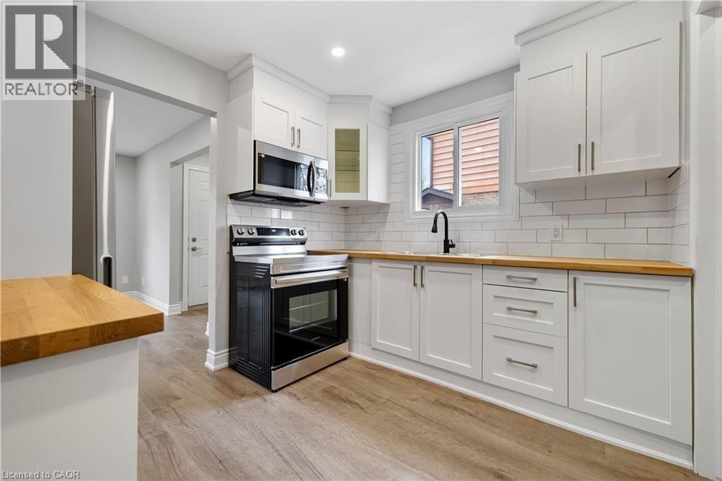 A modern kitchen with white cabinets and a wooden countertop.