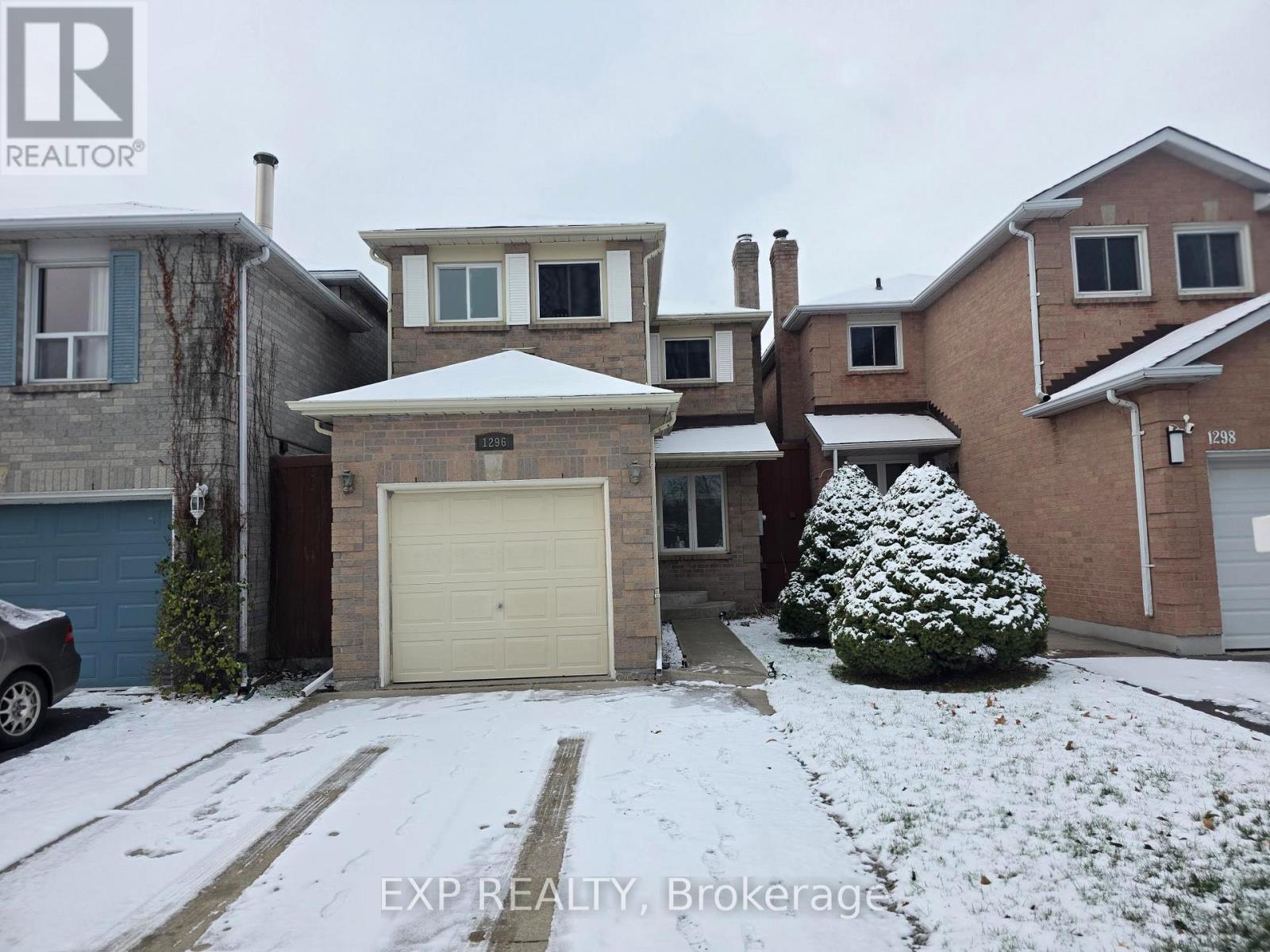A house with a snow-covered front yard and a car parked in the driveway.