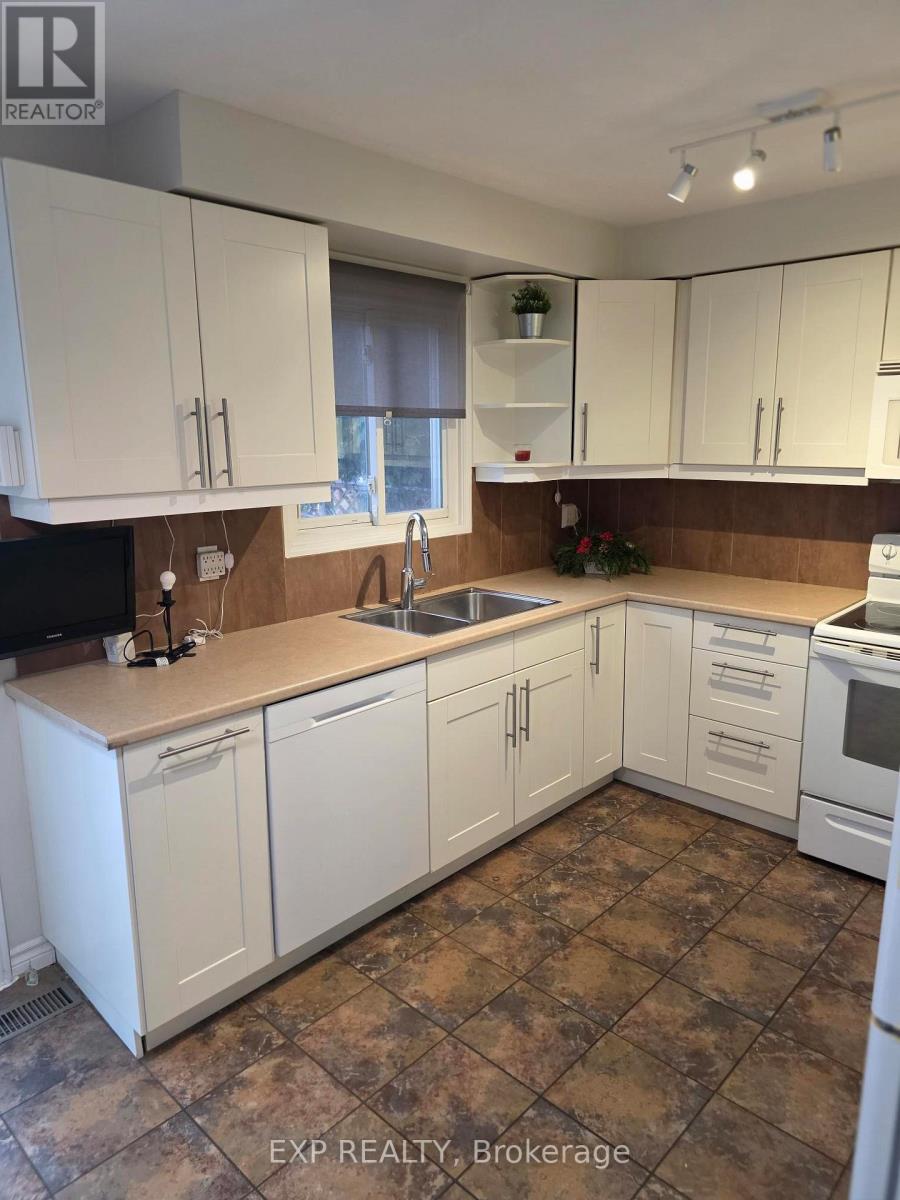 A kitchen with white cabinets and brown countertops.