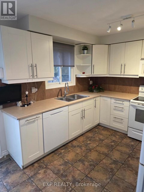 A kitchen with white cabinets and brown countertops.