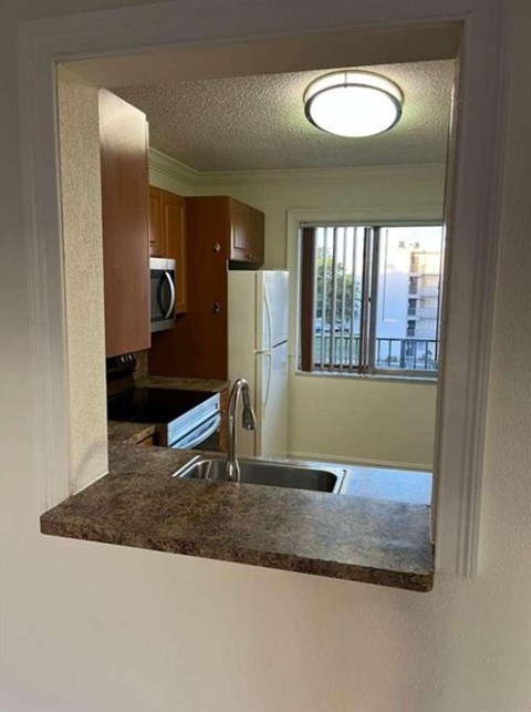 A kitchen with a sink and a refrigerator.