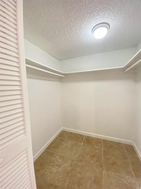 A white closet with a light on the ceiling.