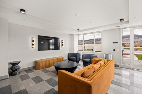 A living room with a brown couch and a black table.