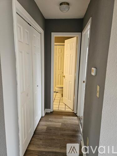 A hallway with a white door on the left and a white door on the right.