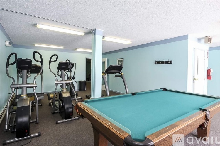 A room with a pool table and exercise equipment.