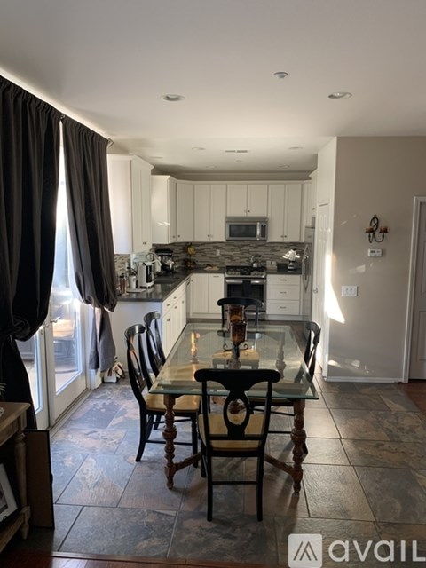 A kitchen with a table and chairs in front of a window.