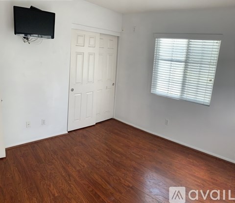 A room with a wooden floor and a white door.
