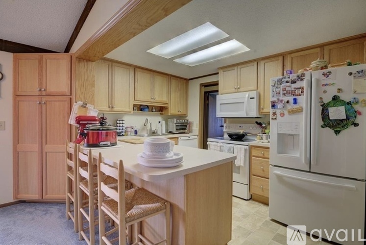 A kitchen with wooden cabinets and a white fridge.