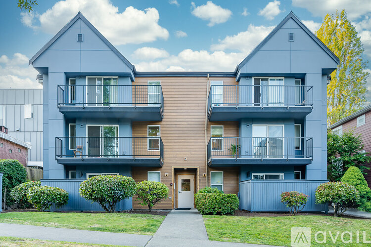 A modern two-story apartment building with balconies and a front entrance.