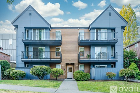 A modern two-story apartment building with balconies and a front entrance.