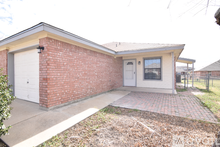 A small house with a brick wall and a white garage door.