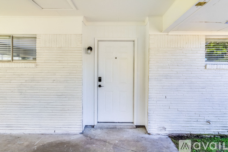 A white door is on the left side of a white wall.