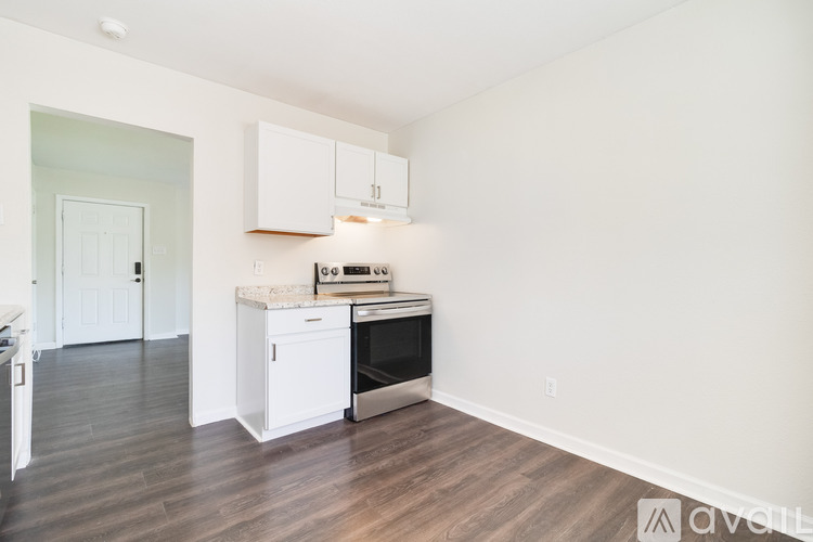 A kitchen with white cabinets and a stove top oven.