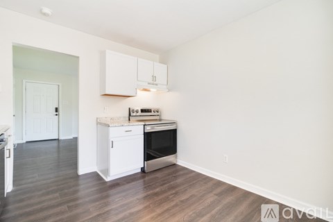 A kitchen with white cabinets and a stove top oven.
