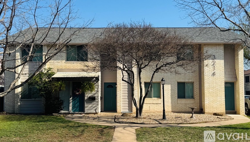A house with a green door and a tree in front.