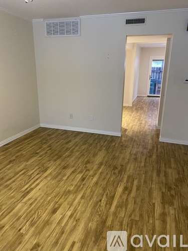 A room with wooden flooring and a white wall.