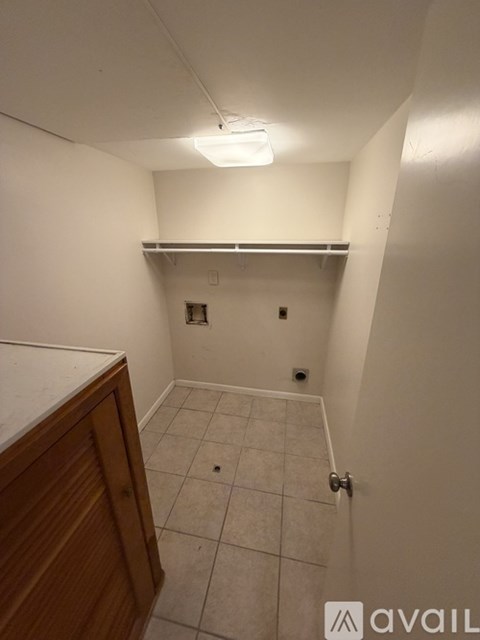 A small, empty room with a door and a cabinet.