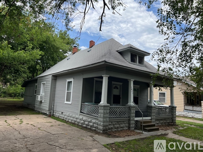 A small house with a porch and a balcony is for sale.