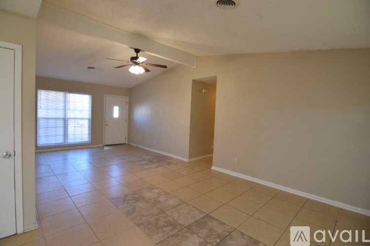 A spacious room with a ceiling fan and tiled flooring.
