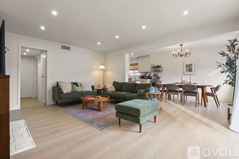 A living room with a green sofa and a wooden coffee table.