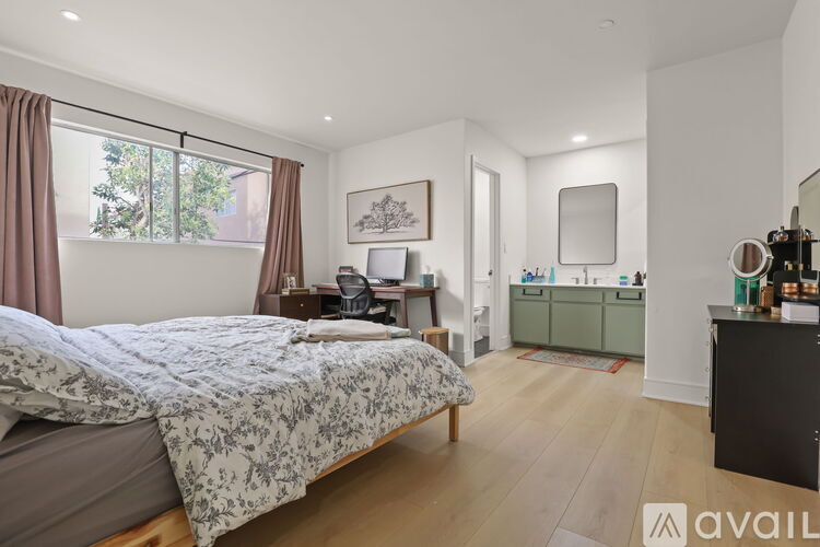 A bedroom with a large bed and a vanity with a mirror.
