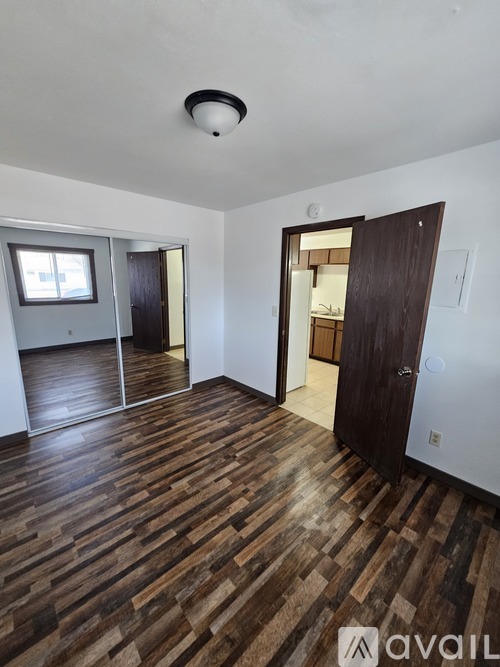 A room with wooden flooring and a ceiling light.