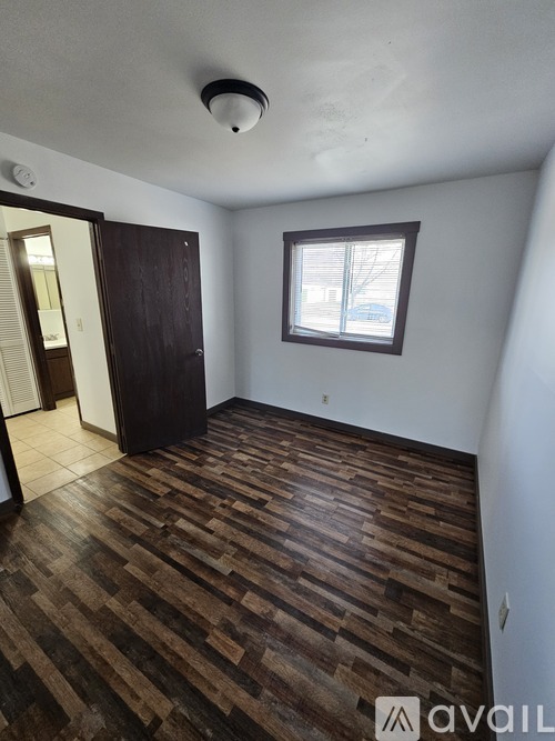 A room with wooden flooring and a window.