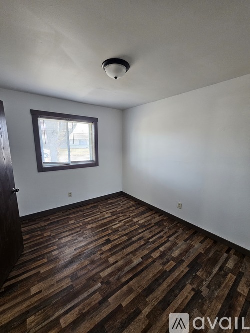 A room with wooden flooring and a window.