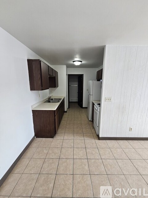 A kitchen with white cabinets and a white refrigerator.