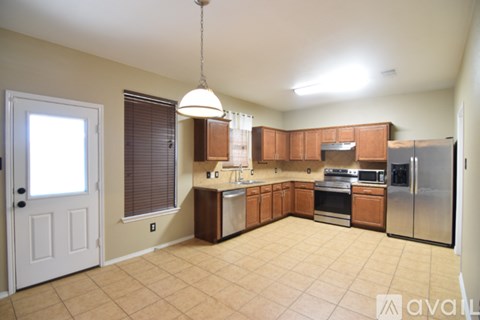 A kitchen with wooden cabinets and a stainless steel refrigerator.