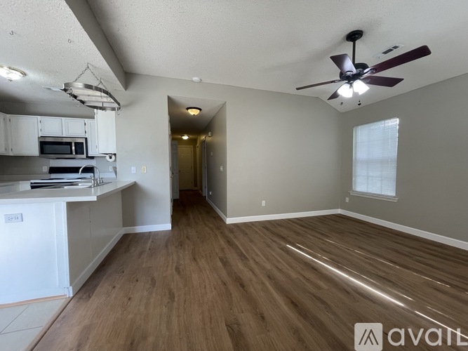 A kitchen with white cabinets and a wooden floor.