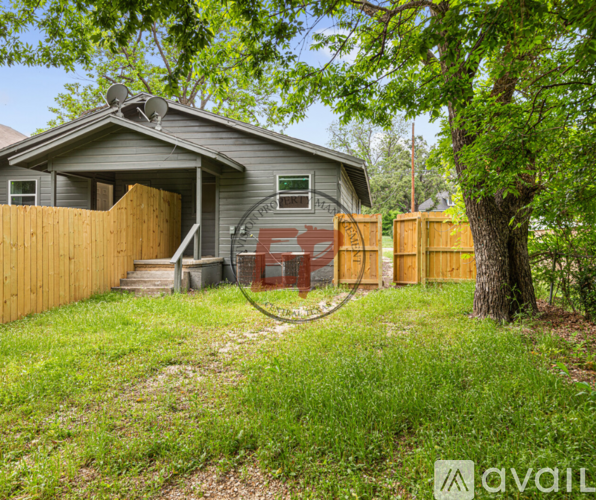 A house with a grey roof and a wooden fence.